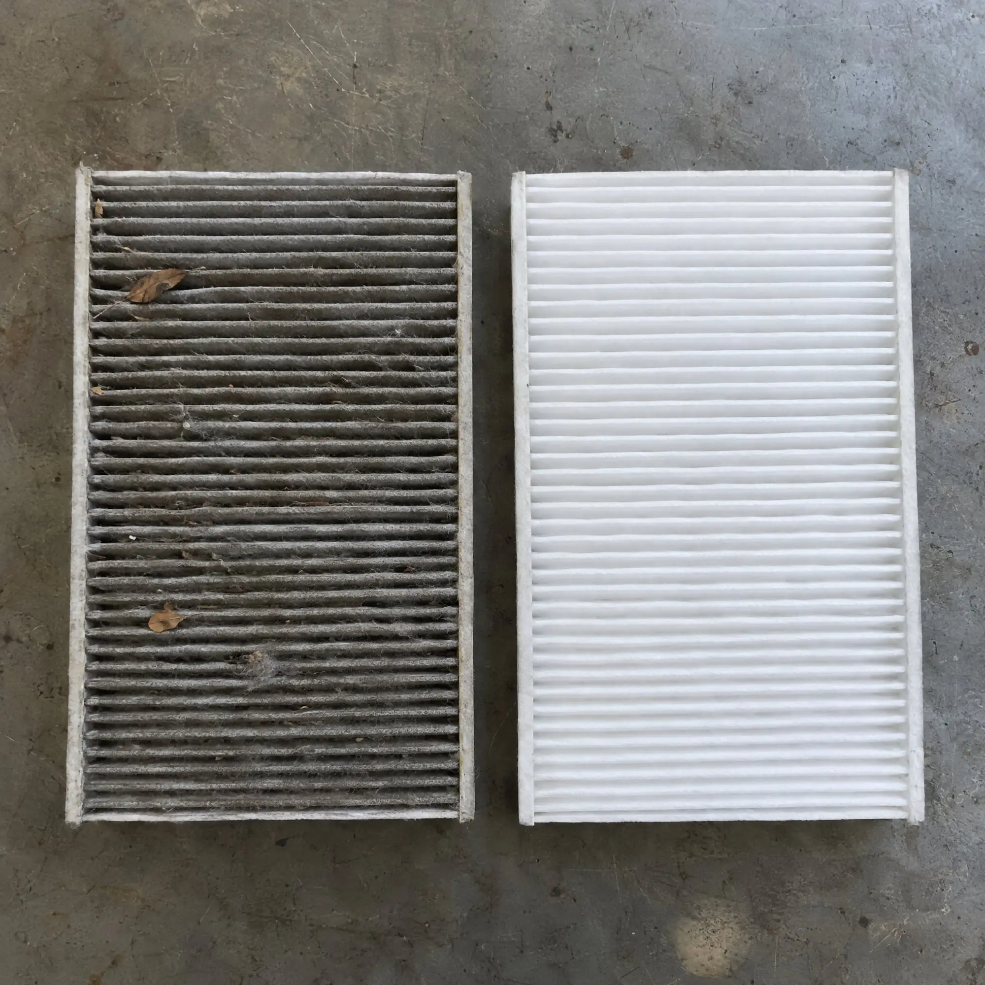 Dirty, clogged cabin air filter next to a clean new filter