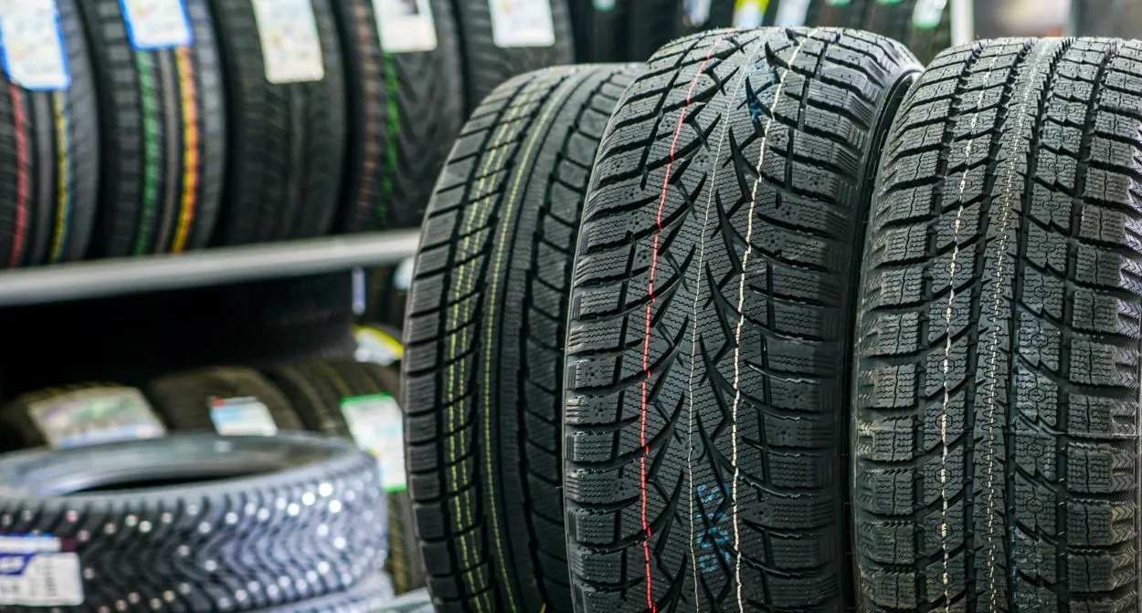 Row of new tires with different tread patterns on a store rack